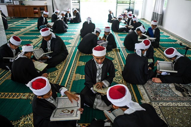 This picture shows Muslim students reading copies of the holy Qoran to observe Nuzul Quran, when the beginnings of the Quran were revealed to the Prophet Mohammed (pbuh), in a mosque in Bentong. PHOTO: AFP