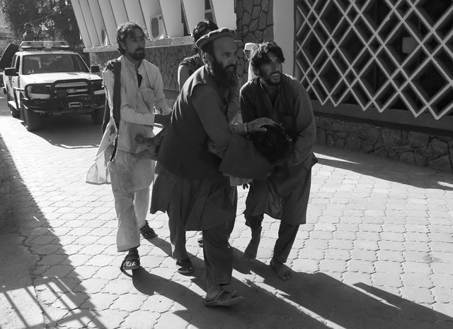 Afghan men carry a wounded person to the hospital after a suicide attack in Jalalabad, Afghanistan June 13, 2019. PHOTO: REUTERS