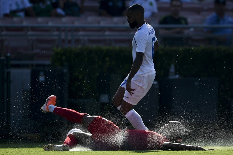Canada defender Derek Cornelius (4) slides for the ball in front of Martinique forward Kevin Parsemain (17) during the second half of group play in the CONCACAF Gold Cup soccer tournament at Rose Bowl. PHOTO: REUTERS