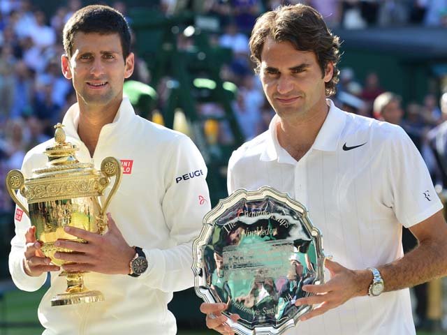 Novak Djokovic, left, shows off the winner's trophy after defeating Roger Federer in the men's final at Wimbledon 2014. PHOTO: AFP