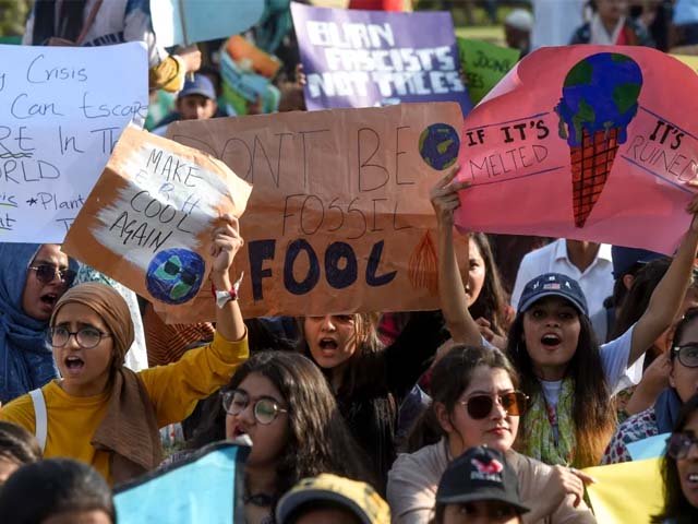Youths hold placards as they march for a climate strike to protest against governmental inaction towards climate change. PHOTO: AFP