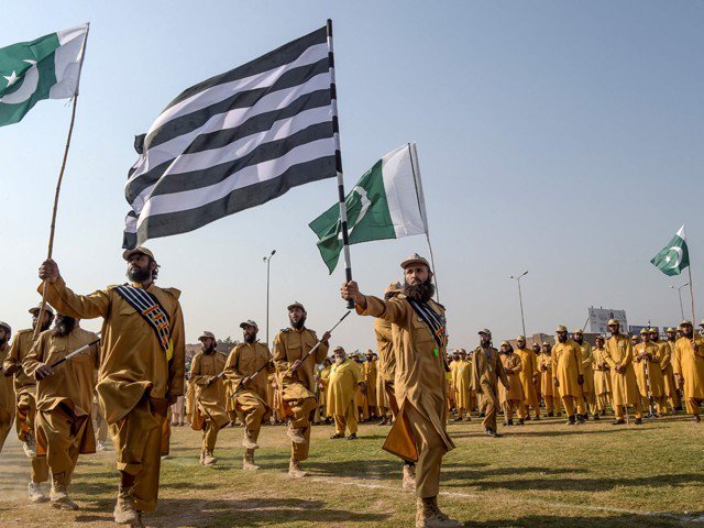 JUI-F activists hold the Pakistani and their party flags as they prepare for Azadi March in Peshawar on October 13, 2019. PHOTO: AFP