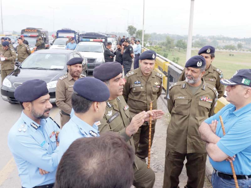 Rawalpindi RPO Ahsan Tufail and Islamabad IG Amir Zulfiqar exchange views on ‘Azadi March’ arrangements at Faizabad. PHOTO: EXPRESS