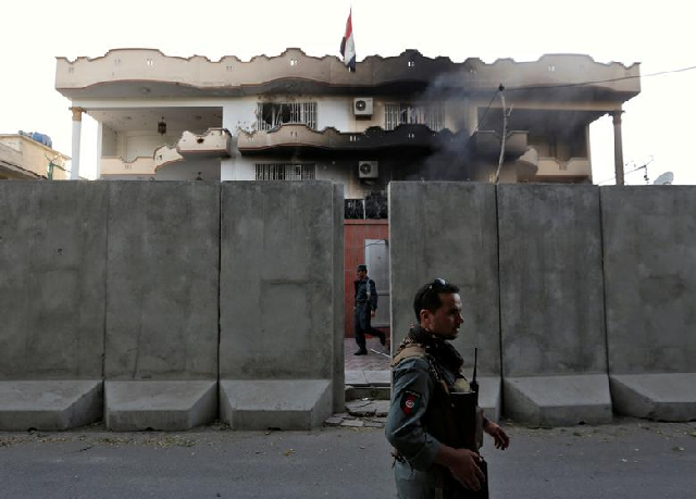 Afghan policemen stand guard outside the Iraqi embassy after an attack in Kabul, Afghanistan. PHOTO: Reuters