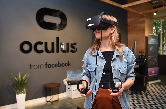 In this file photo taken on October 23, 2019 Facebook employee Elza Uzmanoff tries out an Oculus device at the company's corporate headquarters campus in Menlo Park, California. - Facebook-owned Oculus on November 26, 2019, said it is buying the studio behind hit virtual reality game "Beat Saber" as it looks to expand VR technology to wider audiences. PHOTO: AFP