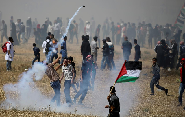 A Palestinian demonstrator hurls back a tear gas canister fired by Israeli forces during a protest. PHOTO: Reuters