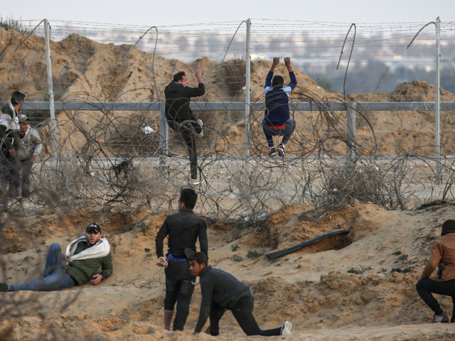 Palestinian demonstrators climb a section of a fence at the Israel-Gaza border, east of Rafah in the southern Gaza Strip, during a protest on December 27, 2019. PHOTO: AFP