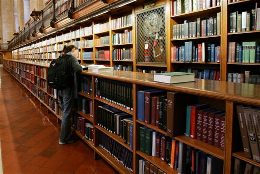 A woman stands among the bookshelves in the main reading room of The New York Public Library. PHOTO: REUTERS