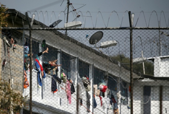 Inmates extend their hands at the Modelo prison in Bogota after a riot killed 23 inmates amid rising tensions over the virus in the penitentiary system. PHOTO: AFP