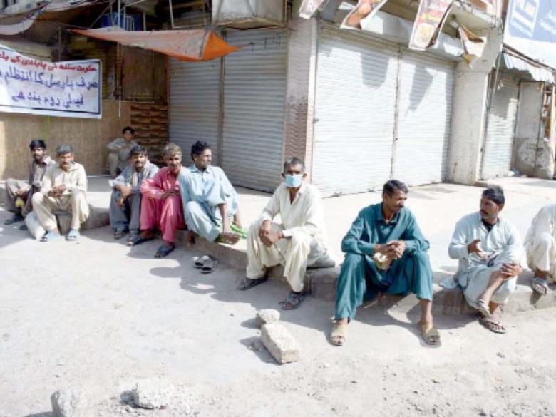 Daily wagers and labourers sit idle on the roadside in Karachi. Lack of employment due to the lockdown means they have no way of earning a livelihood and are one of the most badly affected groups in the current situation. PHOTO: PPI