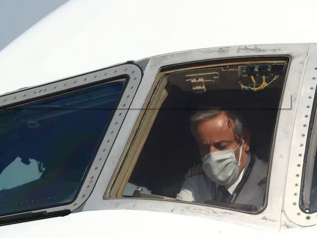 A pilot wearing a protective mask is seen in a cargo aircraft chartered by the UN World Food Programme with medical supplies to help developing countries hit by the coronavirus disease (Covid-19) outbreak, at Liege airport, Belgium. PHOTO: REUTERS/FILE