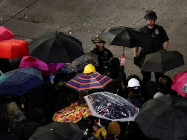 Two Seattle police officers talk to the line of protesters in the front of the barricade as protesters continue to rally early into the morning following the death in Minneapolis police custody of George Floyd, near the department's East Precinct in Seattle, Washington. PHOTO: REUTERS