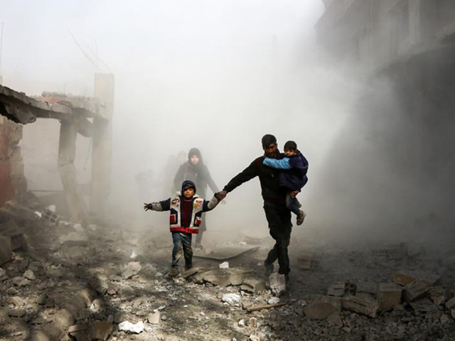 Syrian civilians flee from reported regime air strikes in the rebel-held town of Jisreen, in the besieged Eastern Ghouta region on the outskirts of the capital Damascus, on February 8, 2018. PHOTO: AFP