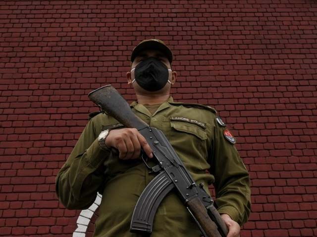 A policeman wearing a facemask stands guard in Lahore. PHOTO: AFP